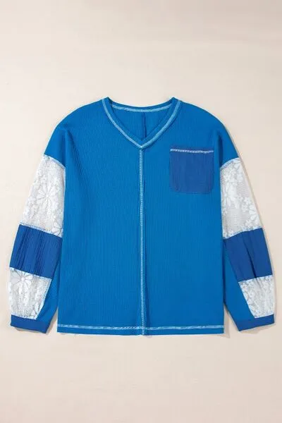 Top met V-hals en kanten patchworkmouwen en stiksels