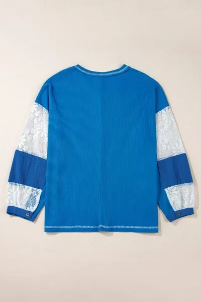 Top met V-hals en kanten patchworkmouwen en stiksels